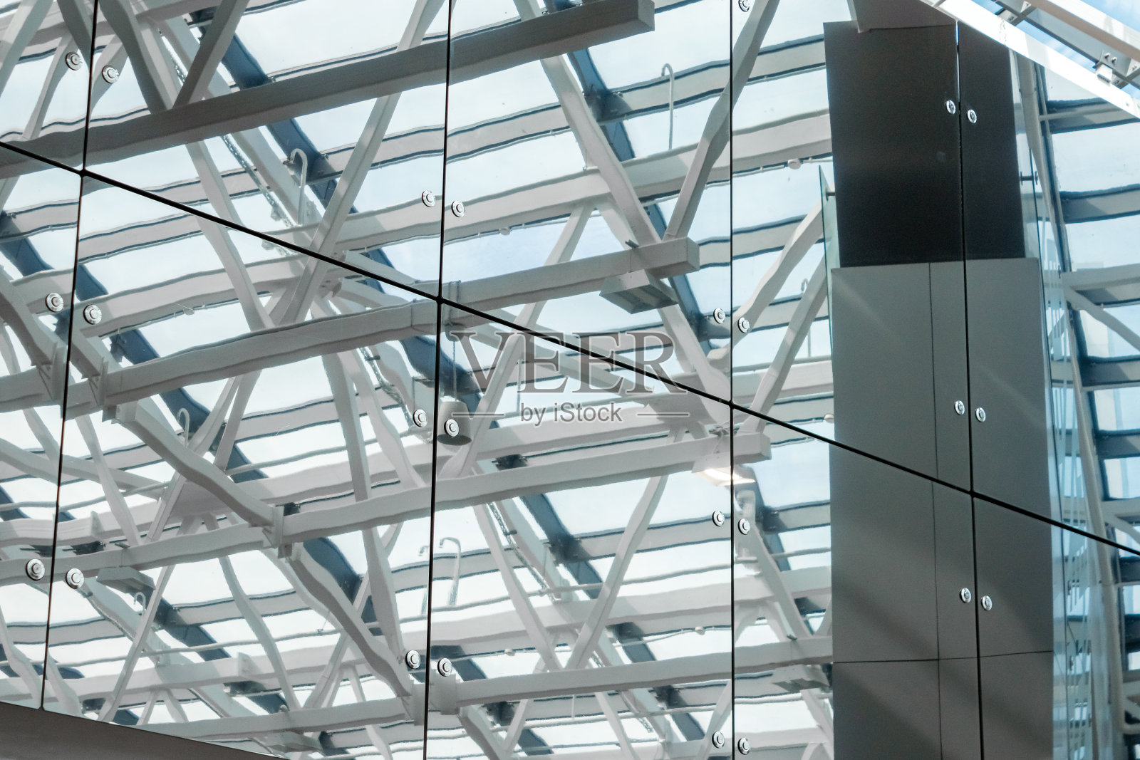 透明玻璃天花板，抽象金属结构。横梁交叉的天花板。带窗户的金属屋顶。照片摄影图片
