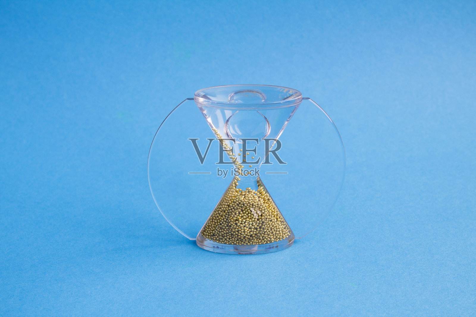 蓝色背景上不同寻常的沙漏。特写镜头。副本的空间。照片摄影图片