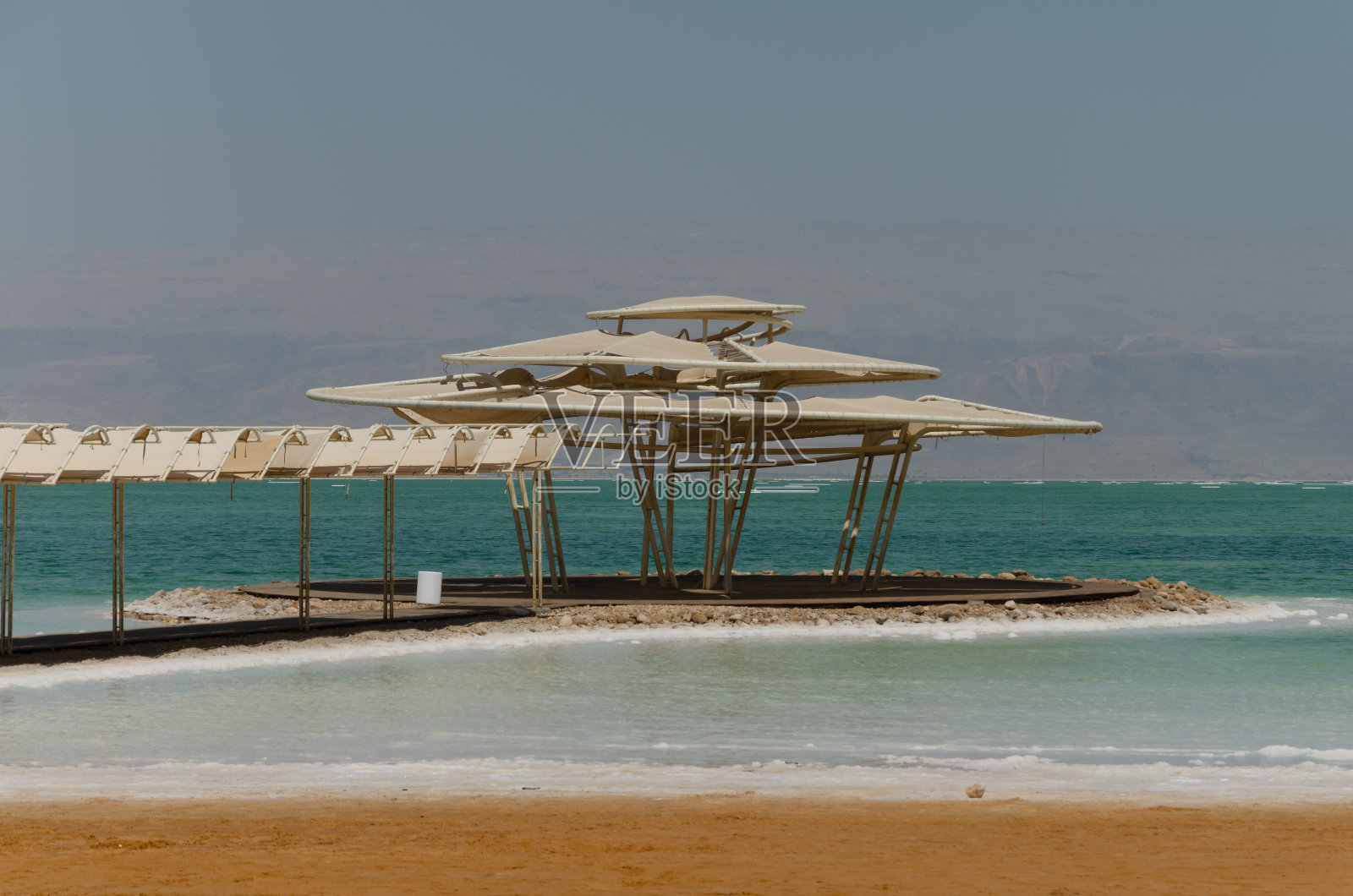 死海海滩上的设备与岸边可见的盐照片摄影图片