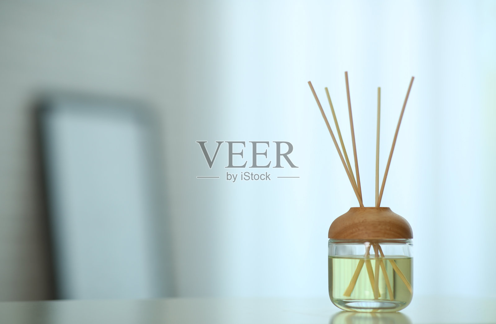 室内餐桌上放有芳香芦苇空气清新剂。空间的文本照片摄影图片