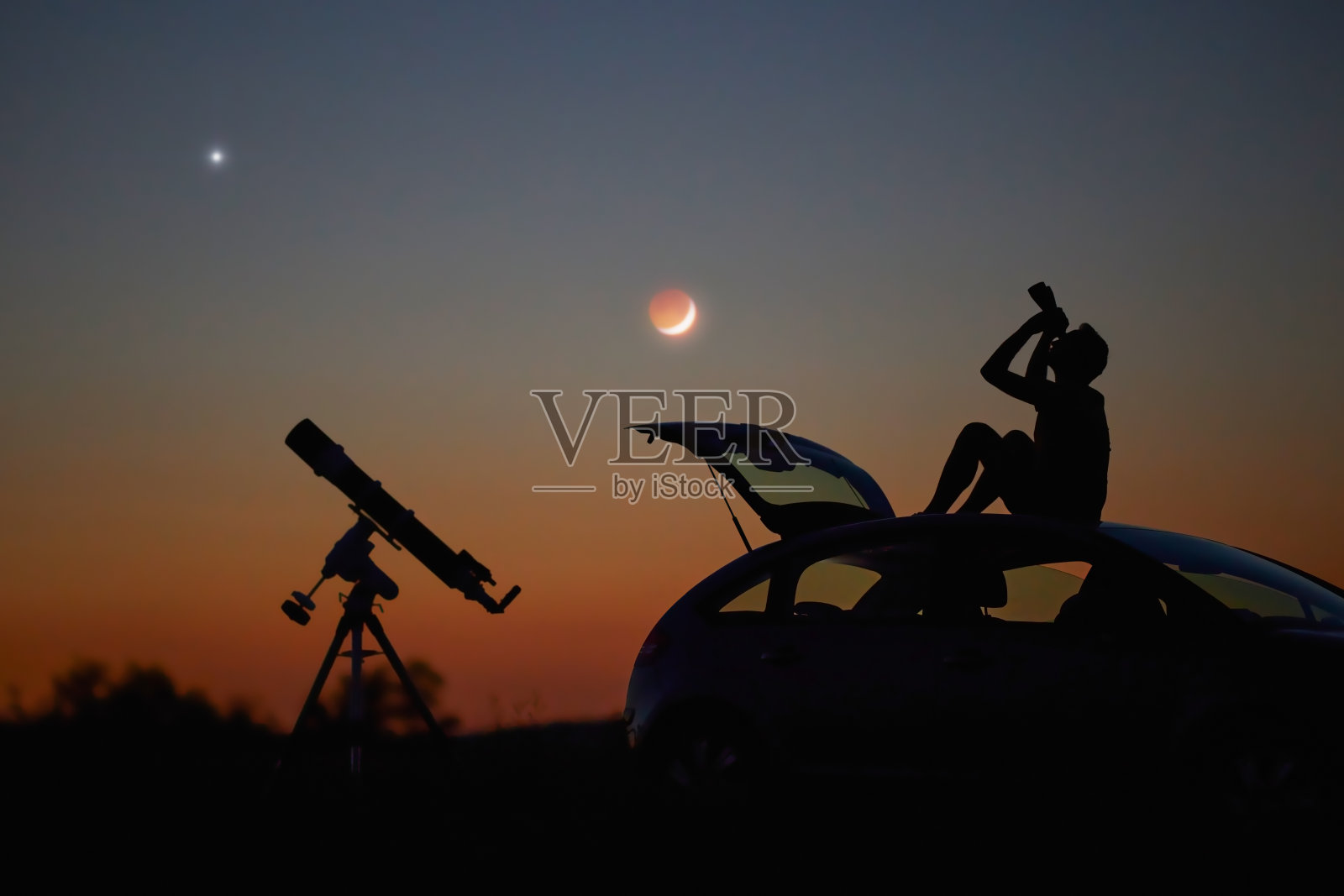 一个人的剪影，汽车，望远镜和乡村星空下。照片摄影图片
