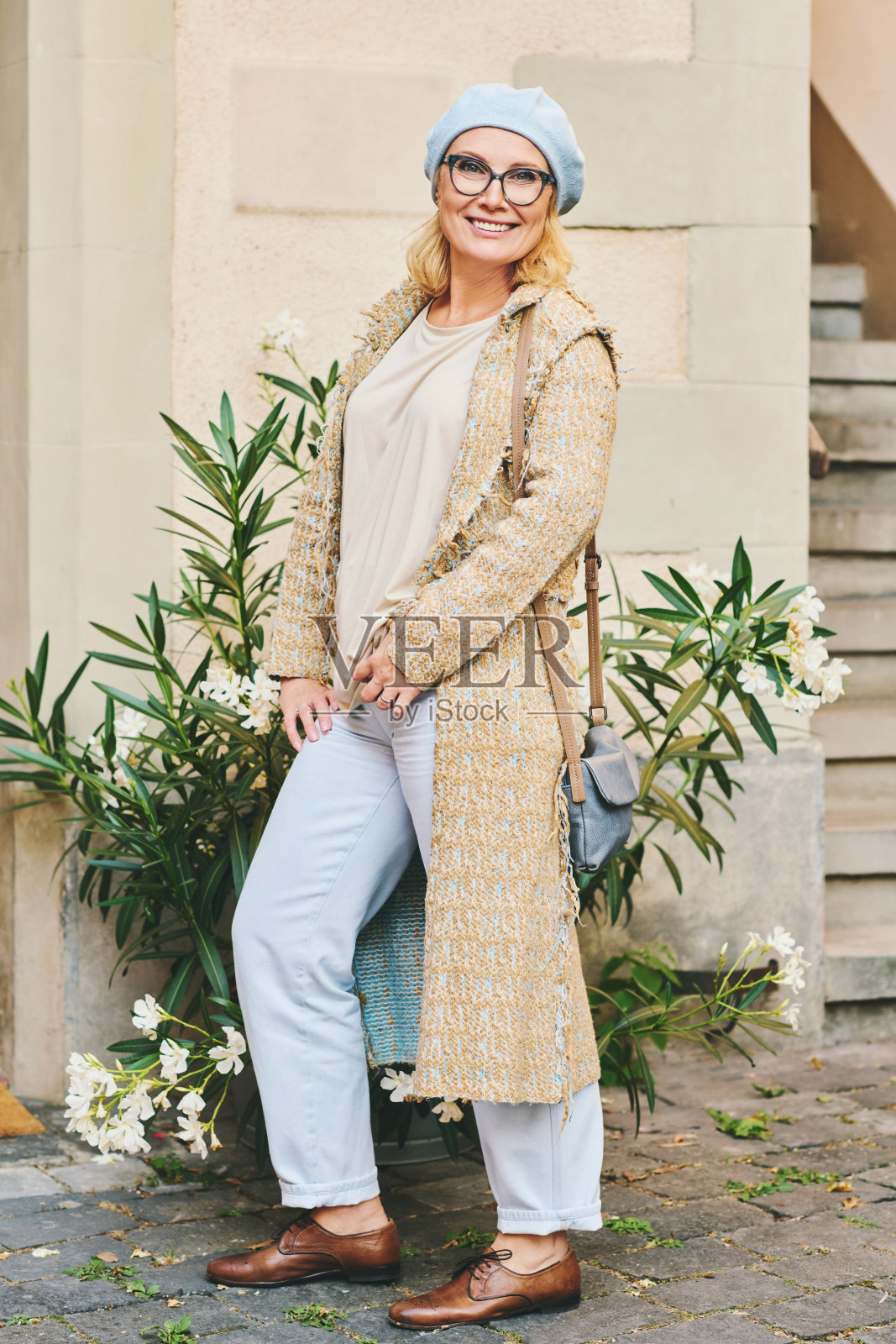 美丽的中年妇女的时尚肖像，在外面摆姿势，穿着长外套照片摄影图片