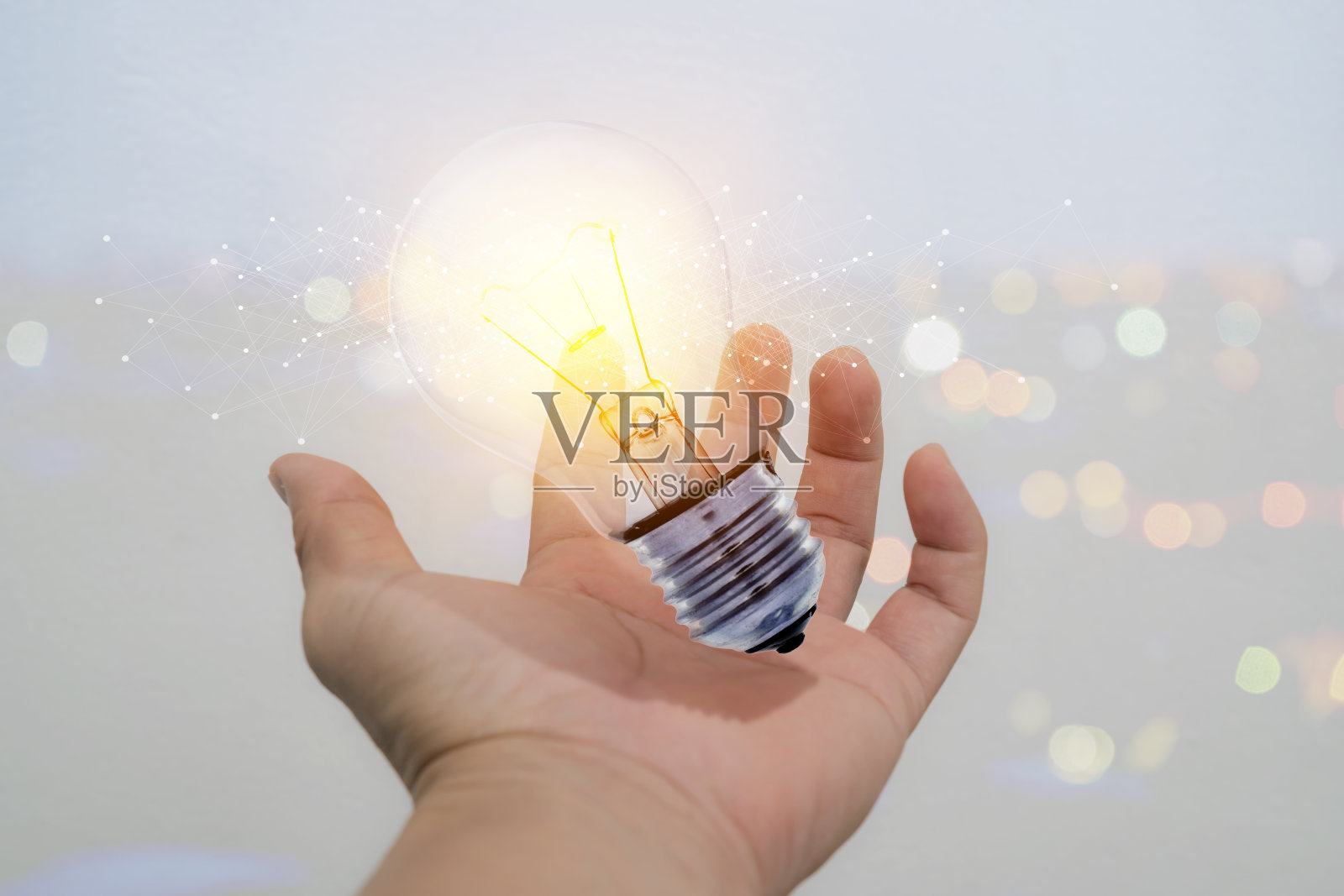 商人手中拿着发光的灯泡招牌照片摄影图片