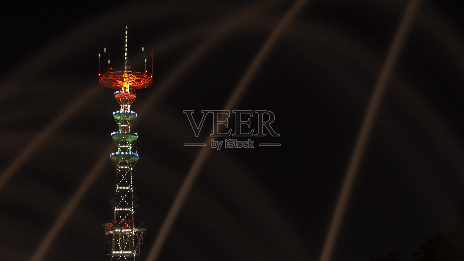 电视塔在节日的灯光下。在前景喷泉与长曝光水滴。节日的概念。照片摄影图片