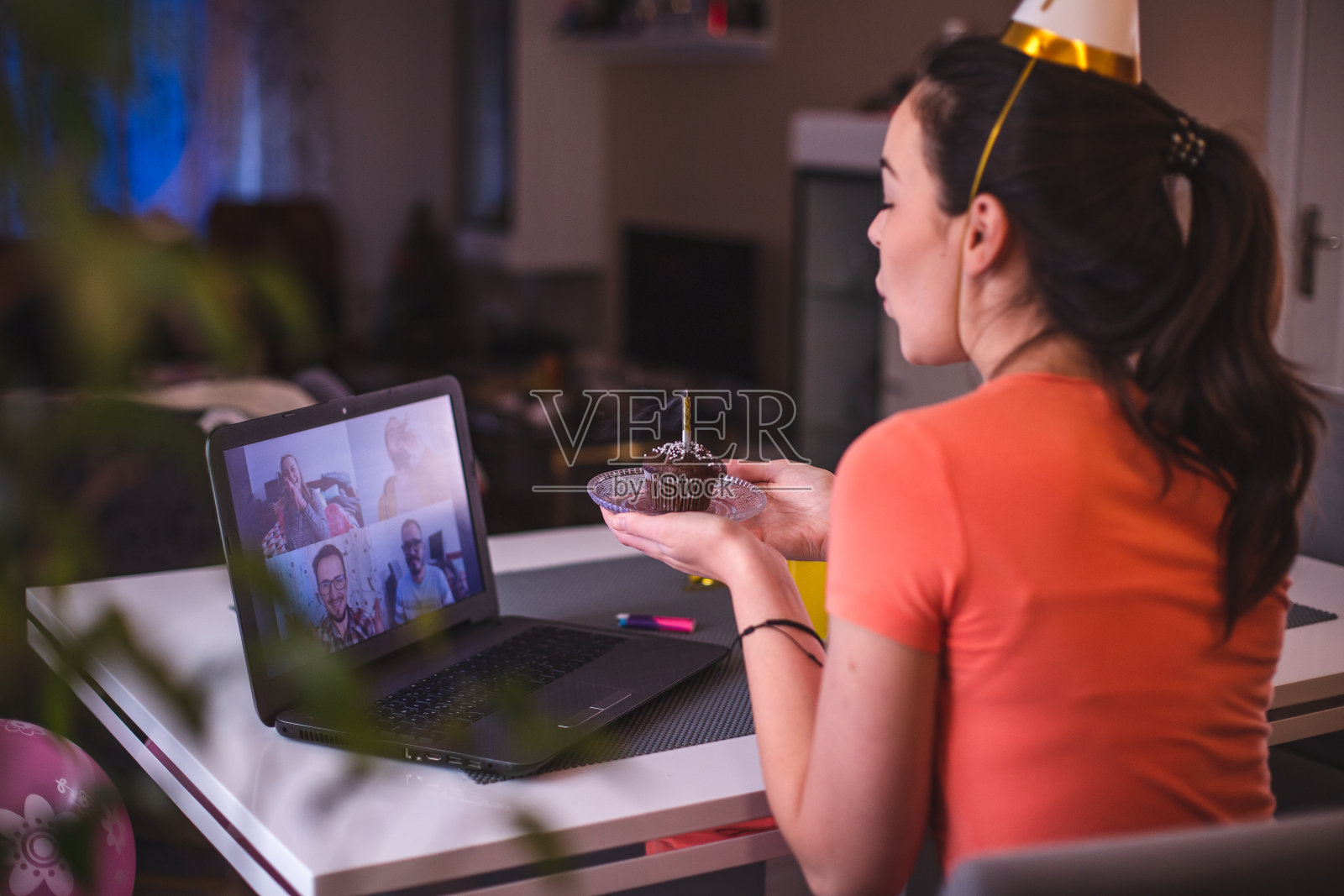 年轻漂亮的女孩在COVID-19冠状病毒大流行期间与她的朋友视频通话庆祝她的生日照片摄影图片