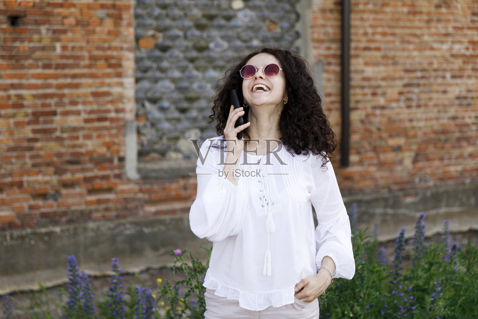 漂亮的年轻女子特写在橙色毛衣在讲手机。户外肖像。照片摄影图片