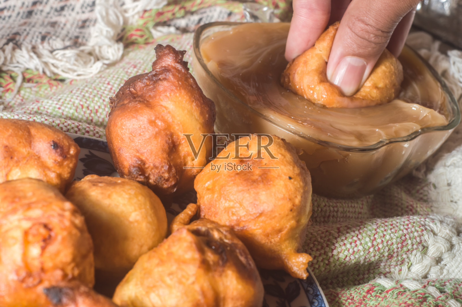 巴西甜叫“bolinho de chuva”雨饺子，手握一个饺子照片摄影图片