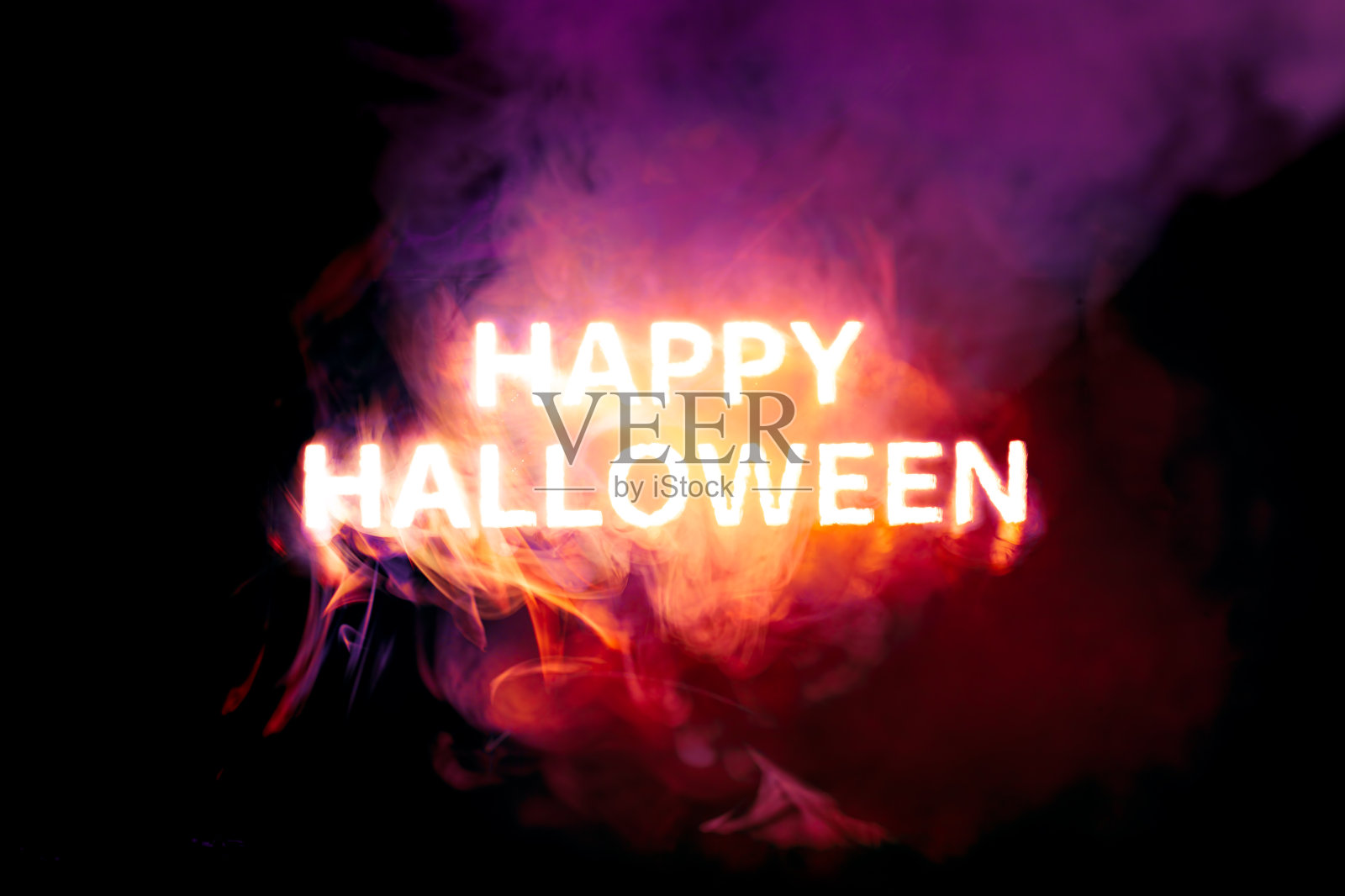 发光快乐的万圣节文本燃烧红色，橙色和紫色的烟照片摄影图片