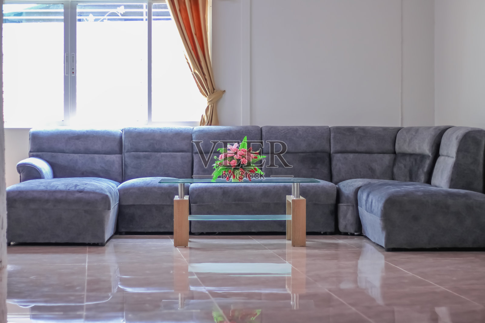 时尚的客厅内部与玫瑰花瓶玻璃桌子，时尚的沙发家具和阳光，金色窗帘在窗口的家庭背景照片摄影图片