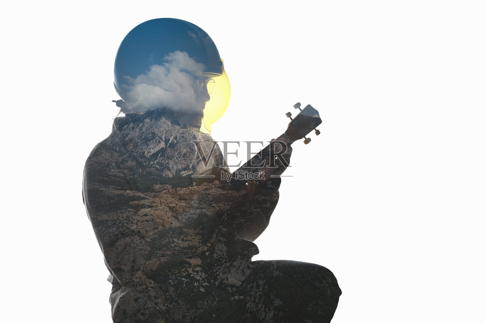 一名男子正在弹吉他，背景是自然景观照片摄影图片