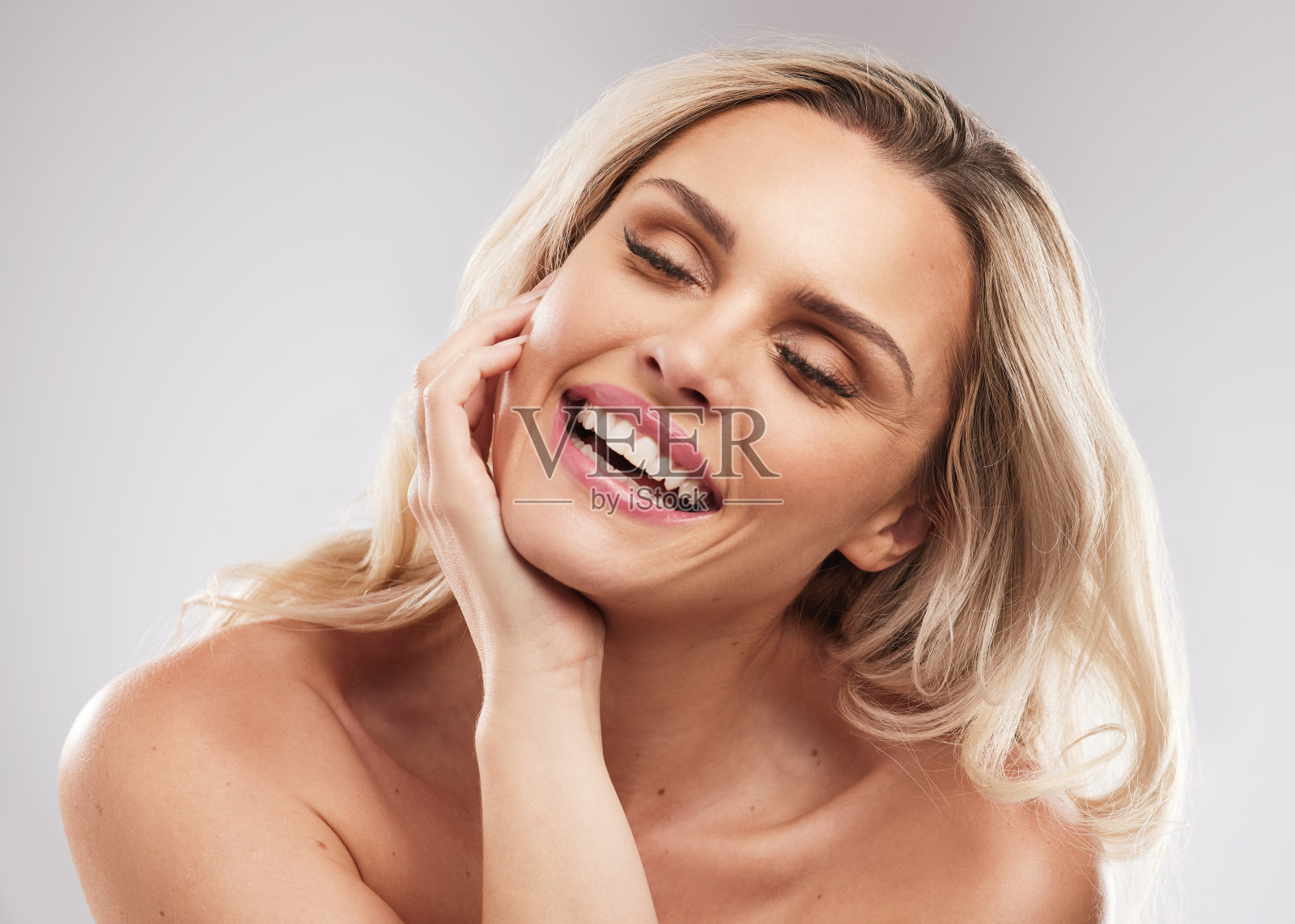 摄影室拍摄的一个美丽的年轻女子站在灰色的背景照片摄影图片