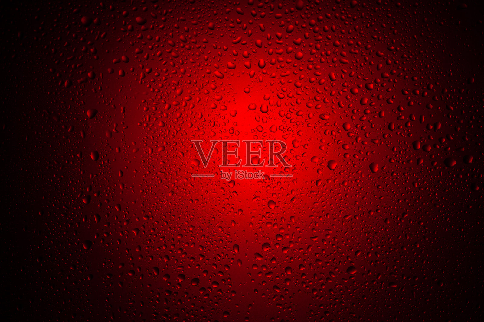 红色霓虹灯下玻璃上的水滴。照片摄影图片