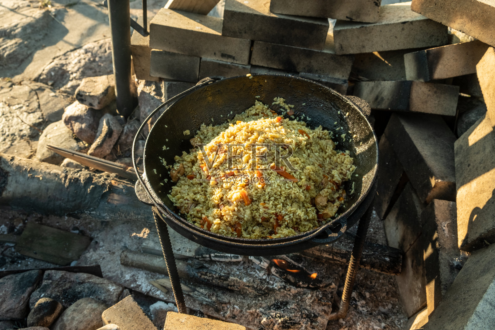 在大锅里，在火上烹饪食物。传统的亚洲食物是肉饭。照片摄影图片
