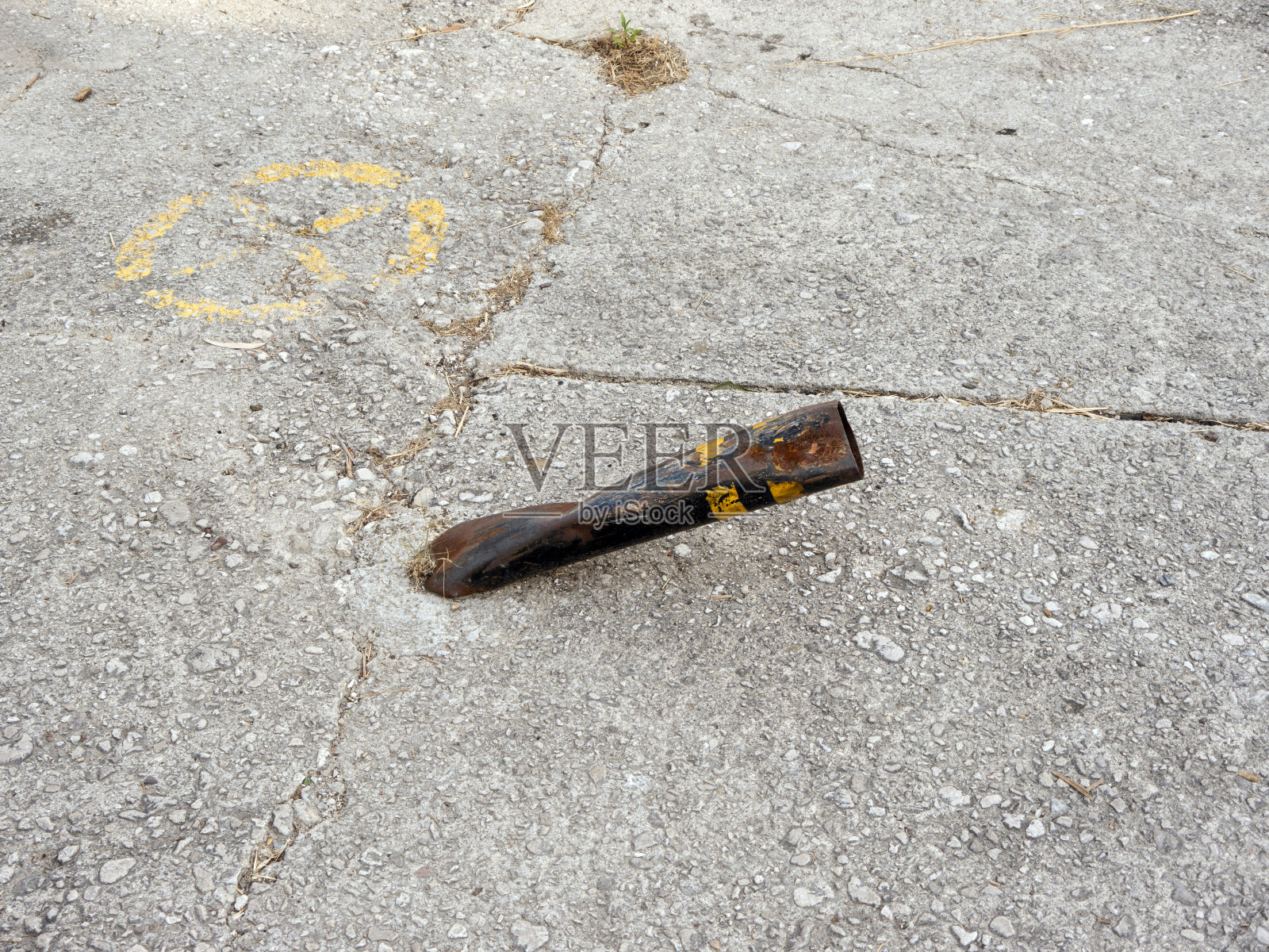 皱巴巴的金属停车柱与黄色条纹水泥区域近侧视图照片摄影图片