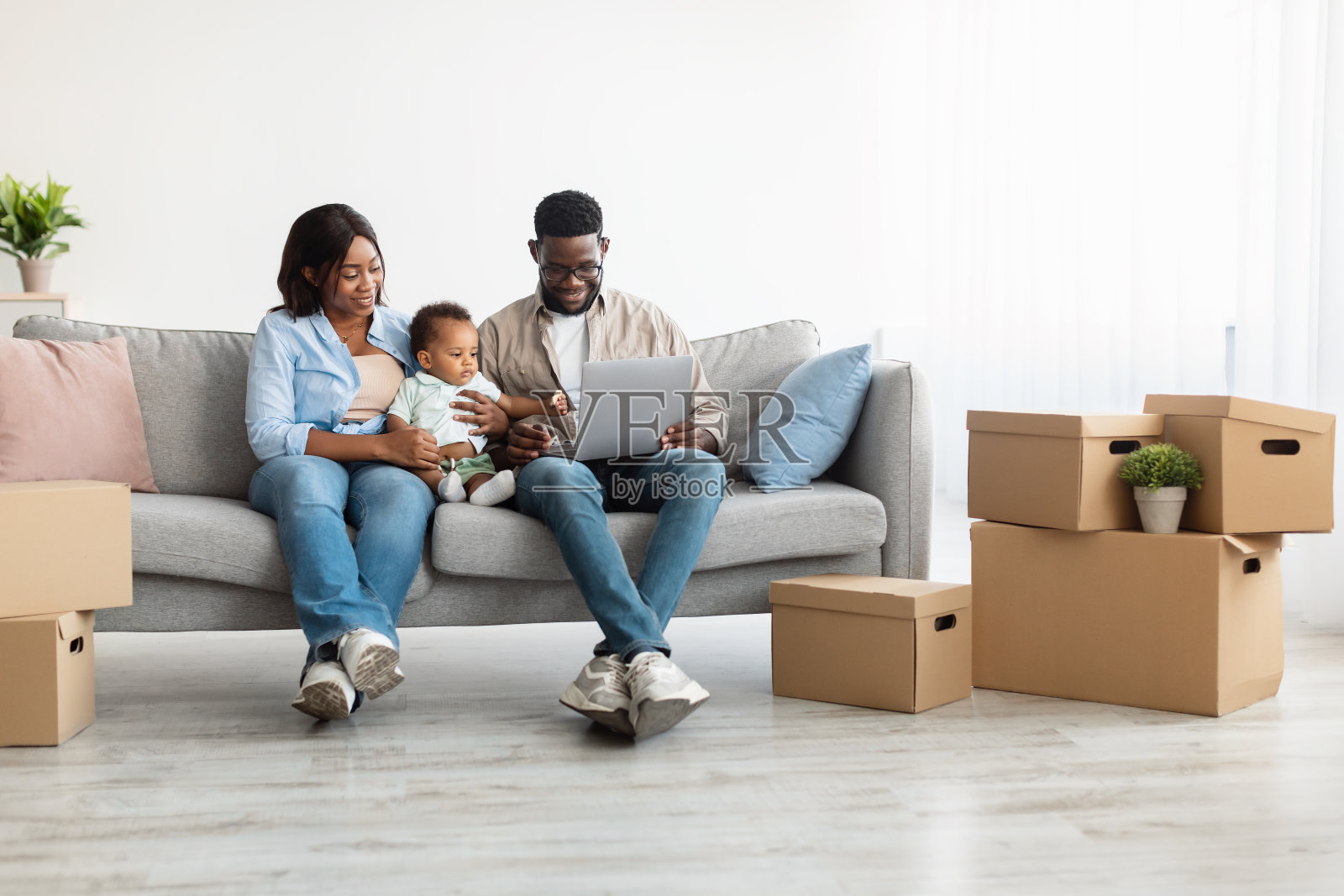 搬迁后快乐的男人、女人和孩子在使用笔记本电脑照片摄影图片