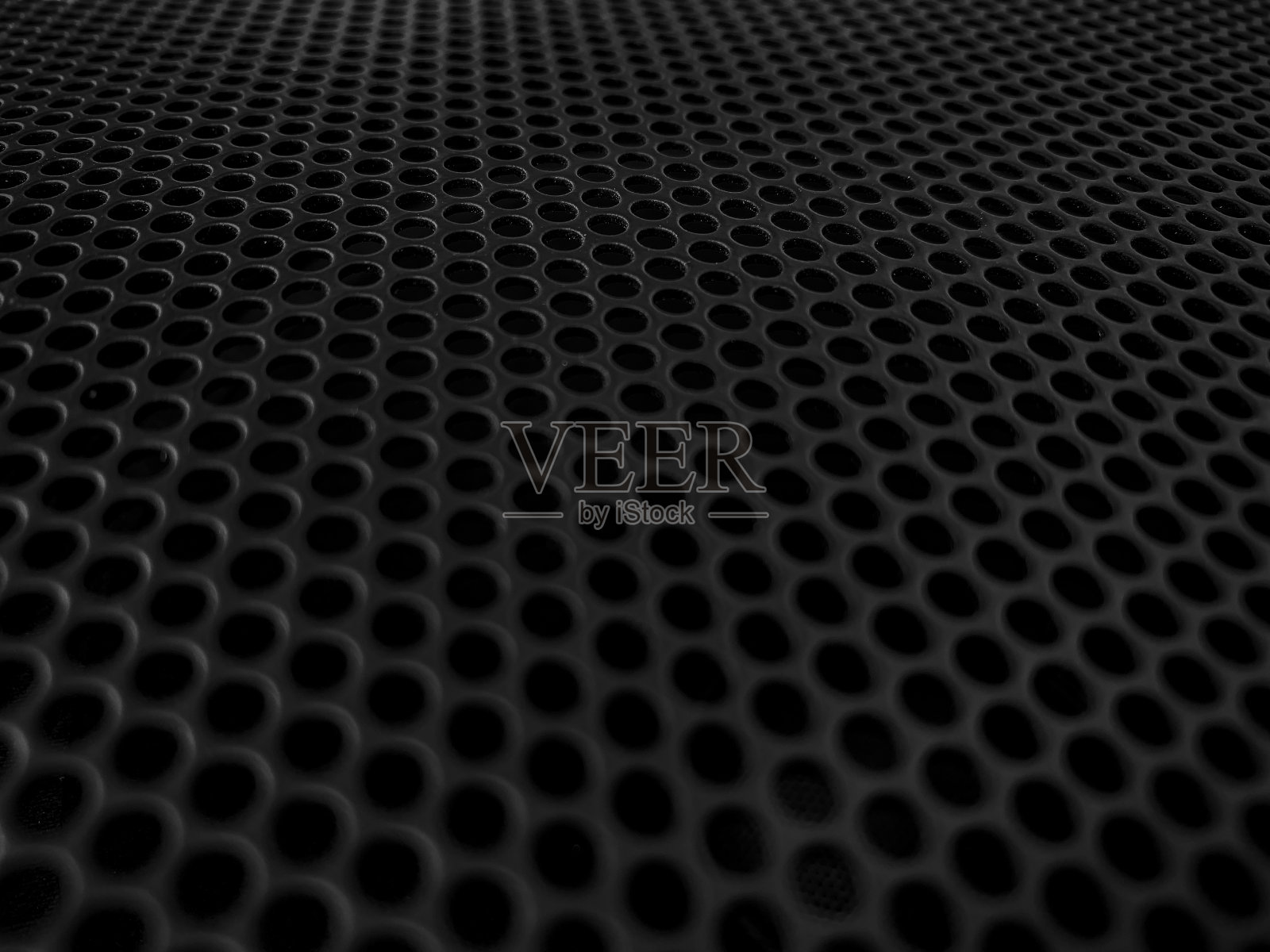 现代音响系统上带有蜂巢的保护性装饰金属格栅。照片摄影图片