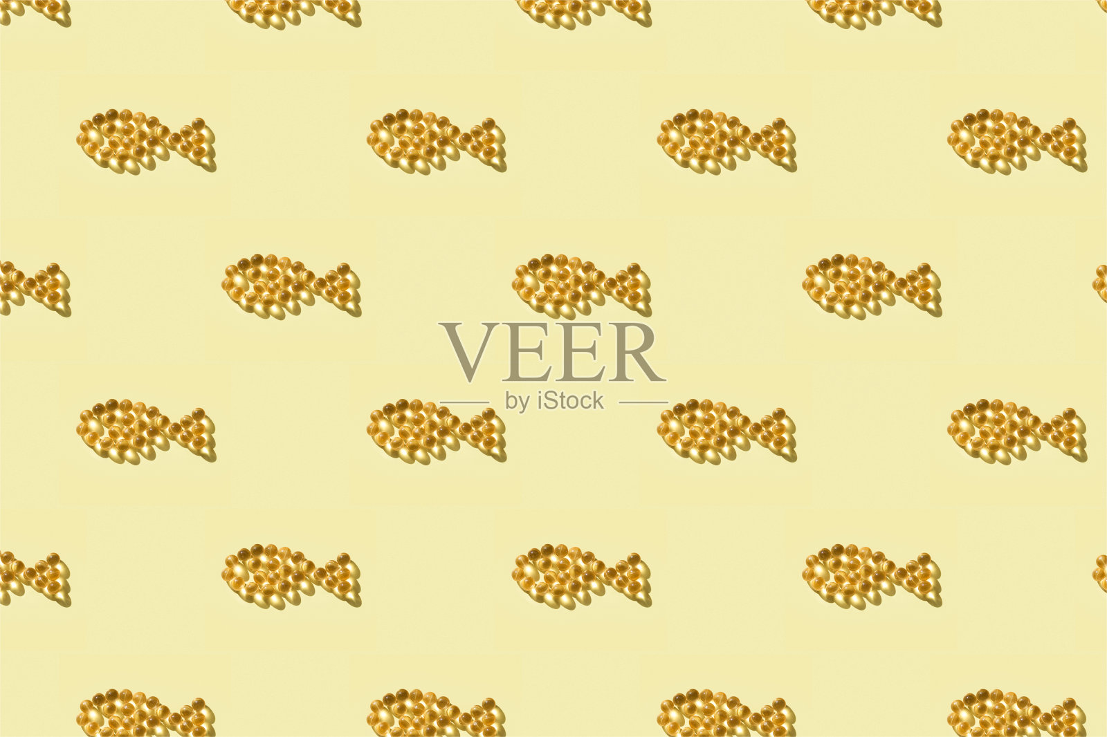 无缝模式从鱼油胶囊在鱼的形状在黄色的背景。照片摄影图片