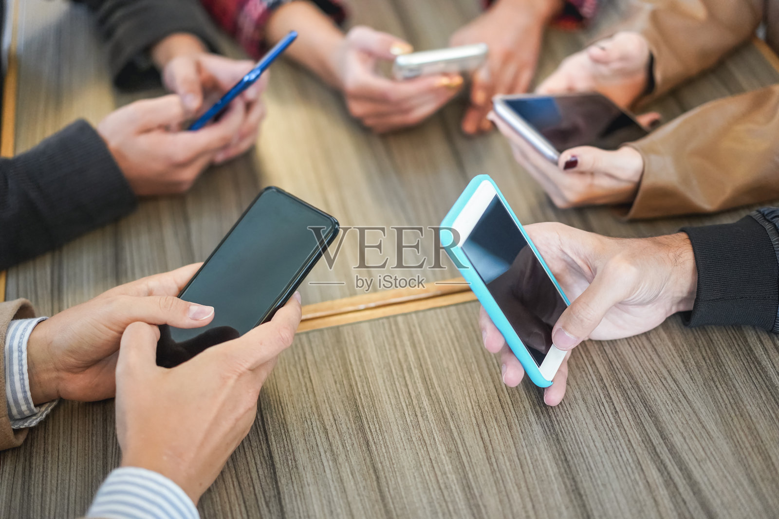 一起玩手机的年轻朋友们——关注右手握着的智能手机照片摄影图片