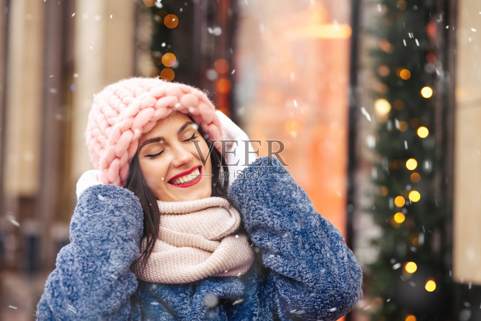 快乐的女人走在城市的花环在下雪照片摄影图片
