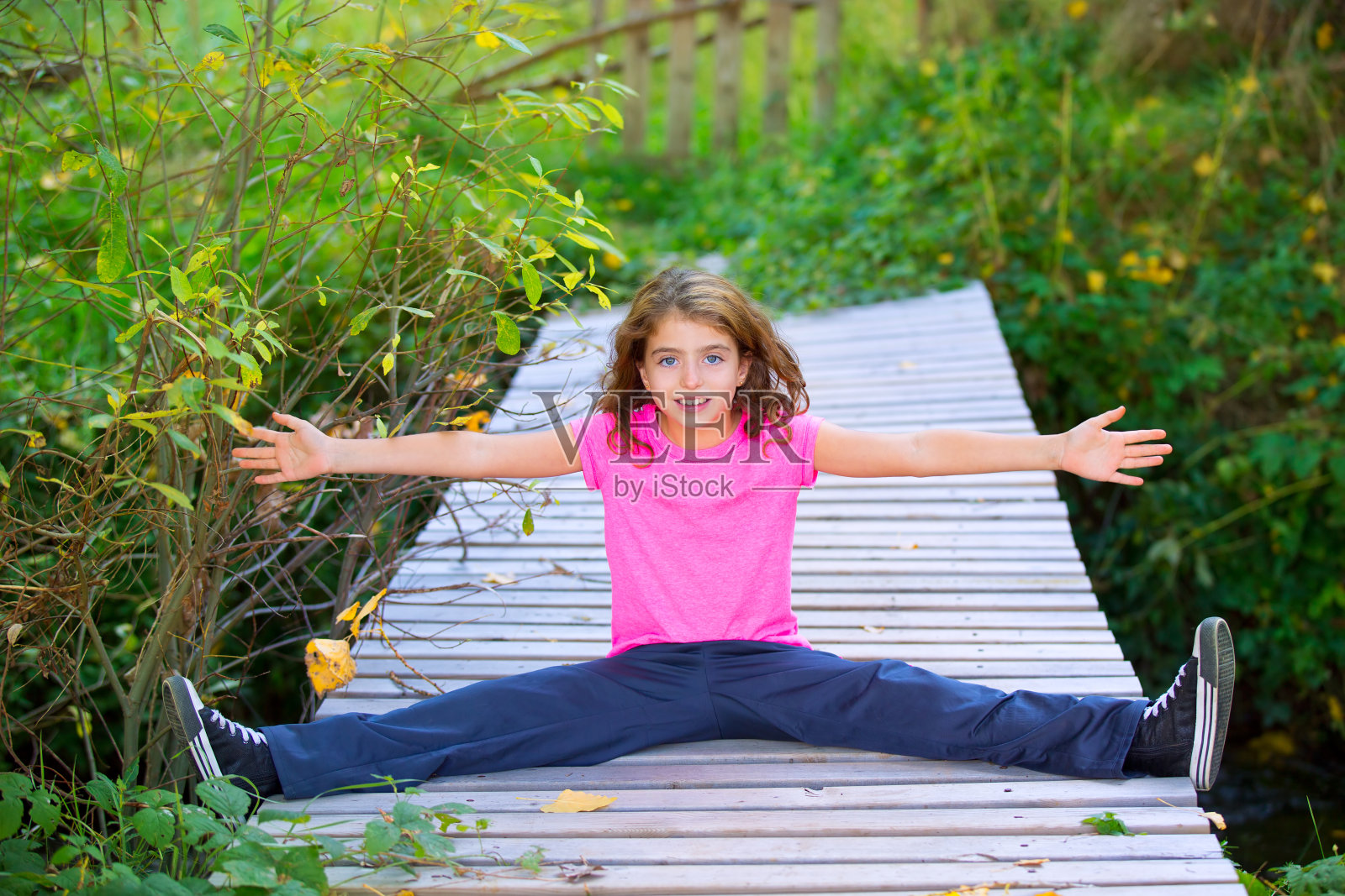 小女孩在秋天微笑着张开双臂和双腿照片摄影图片