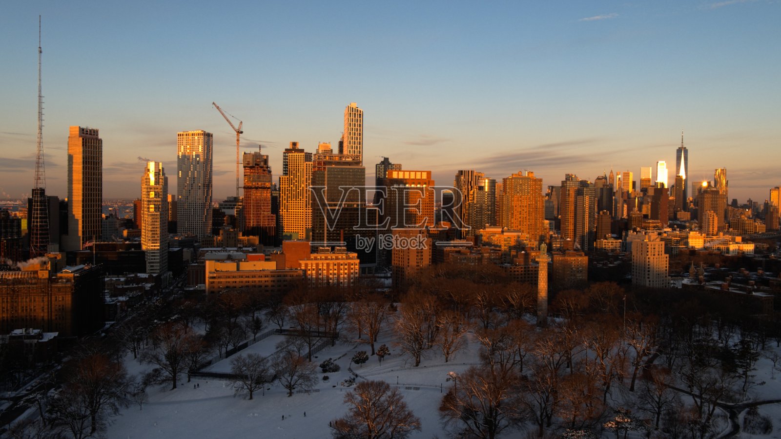 冬季晴朗的黎明时分，被雪覆盖的格林堡公园上空，布鲁克林市中心和曼哈顿天际线的鸟瞰图照片摄影图片
