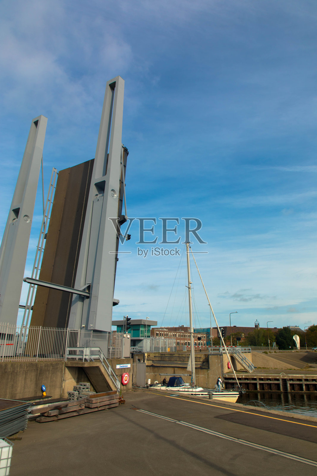将zeeedoksluis ind den Helder的桥抬过运河，让船只通过。照片摄影图片
