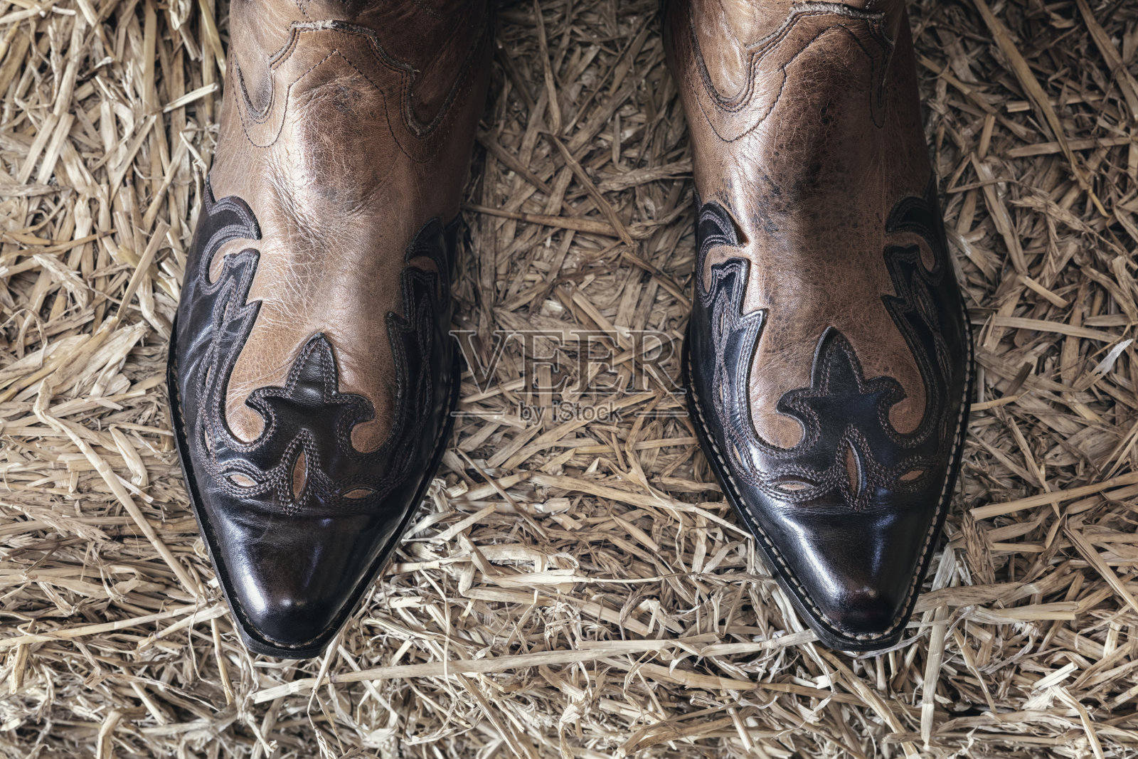 牛仔靴踩在谷仓里的干草上照片摄影图片
