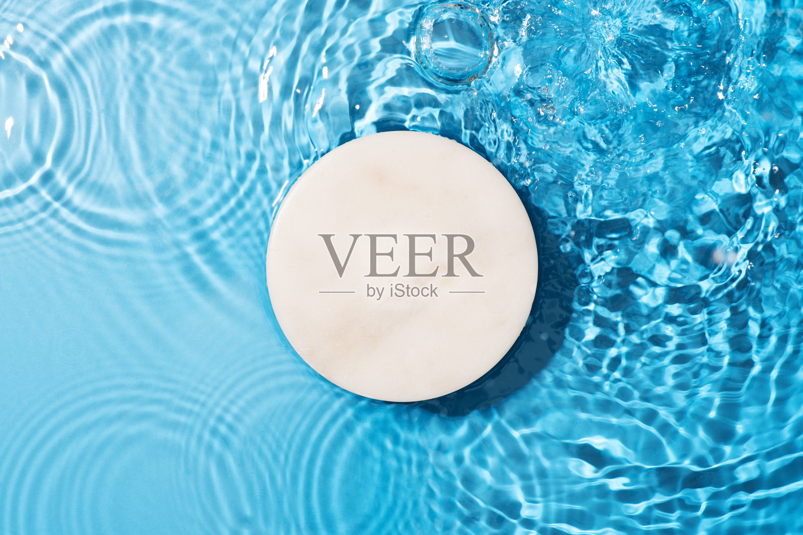 透明干净的蓝水背景与讲台和阳光反射照片摄影图片