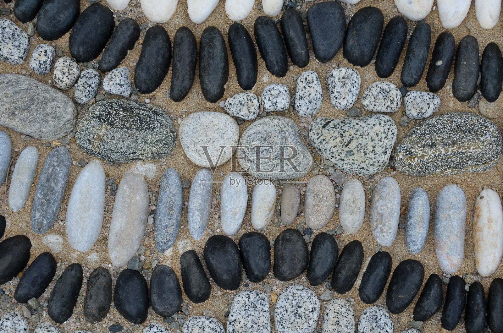 黑色和白色的云朵或巨石的马赛克。花的形状和涟漪，波浪在混凝土中。室外的聚光灯被石头包围着。园林建筑。照片摄影图片