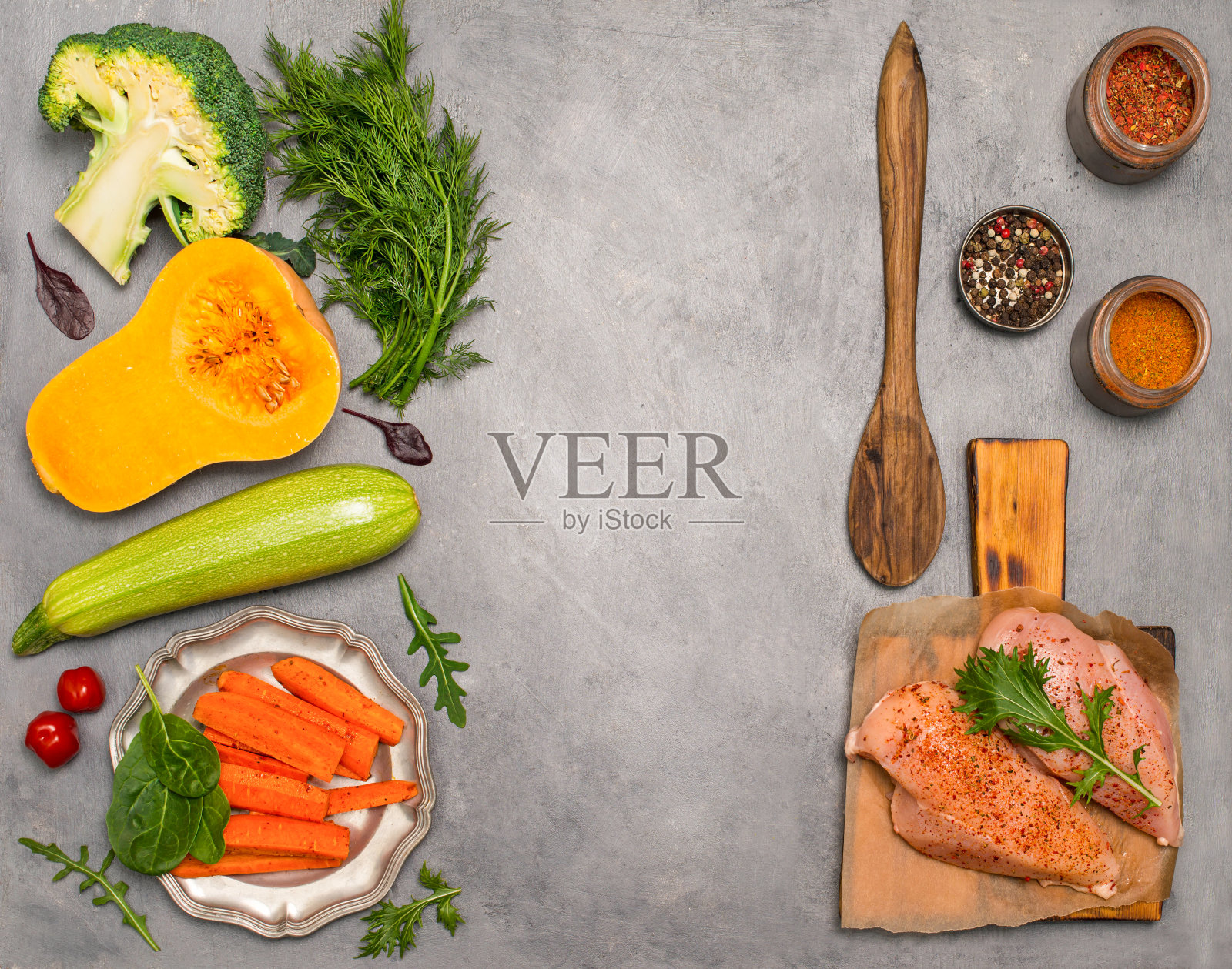 健康饮食。在灰色背景下烹饪的原料。生鸡胸肉放在砧板上，蔬菜和香料。照片摄影图片