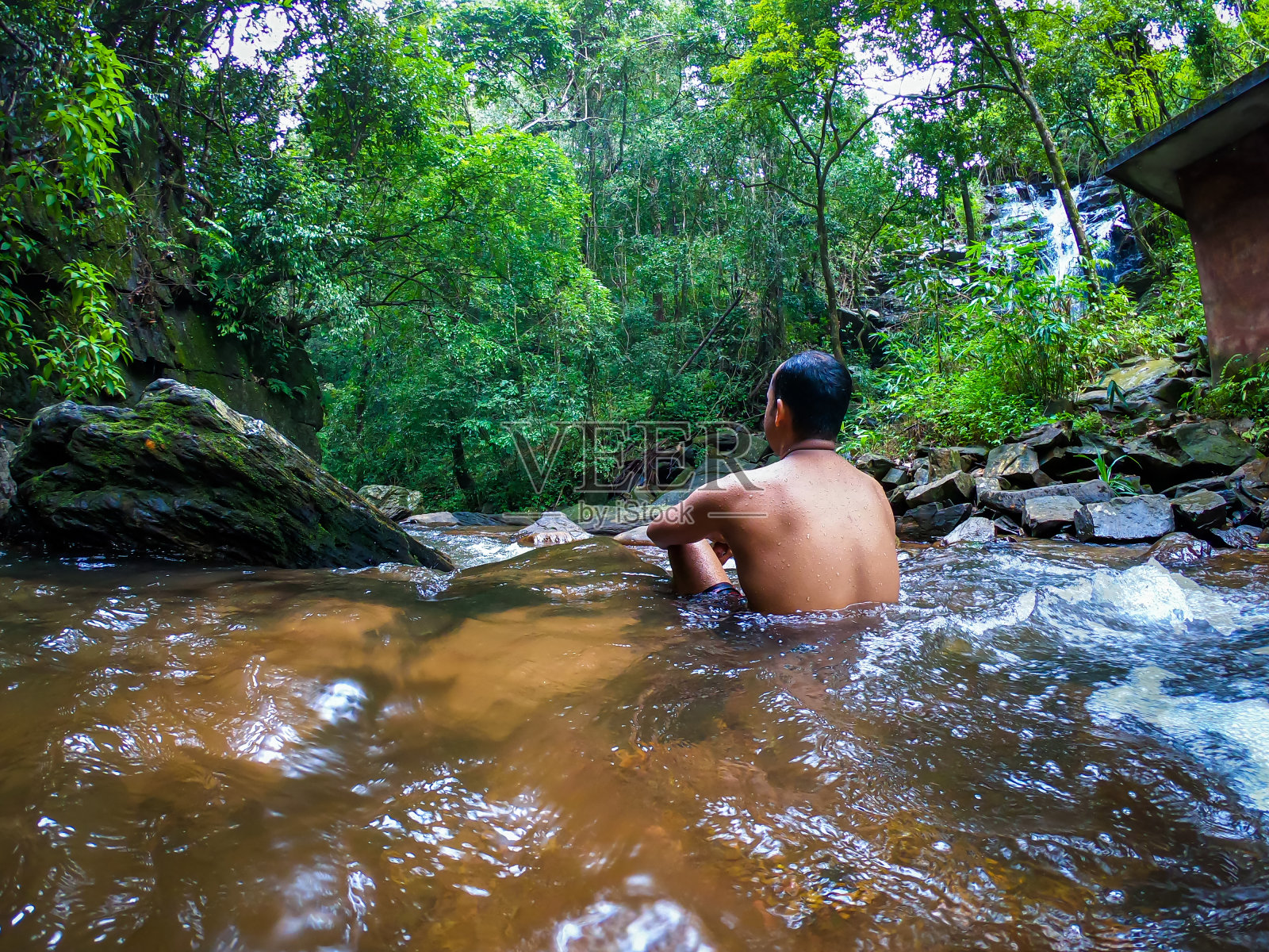 从不同的角度，在绿色森林的自然瀑布中沉默的人照片摄影图片