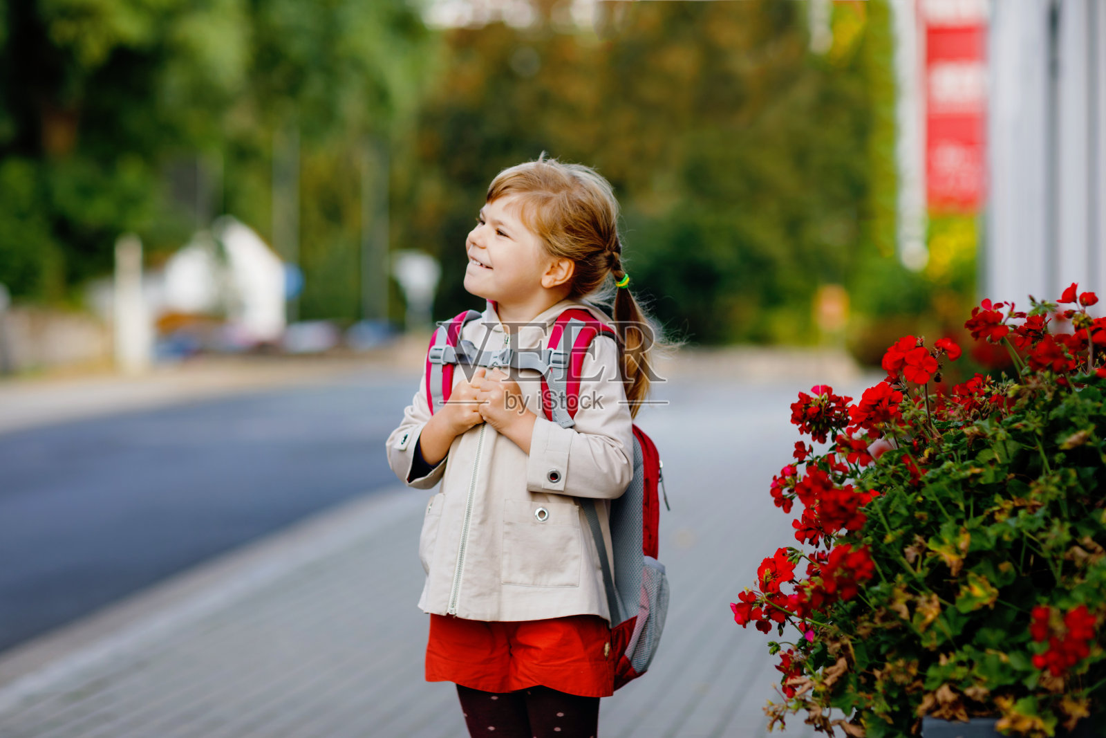 可爱的学前班小女孩要去游戏学校。健康的幼儿步行去幼儿园和幼儿园。快乐的孩子背着背包在城市的街道上，户外。照片摄影图片