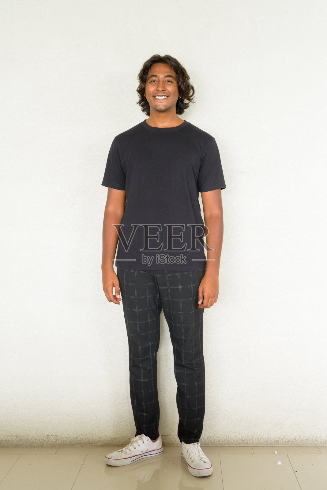 英俊的年轻印度人的全身肖像站在朴素的背景照片摄影图片