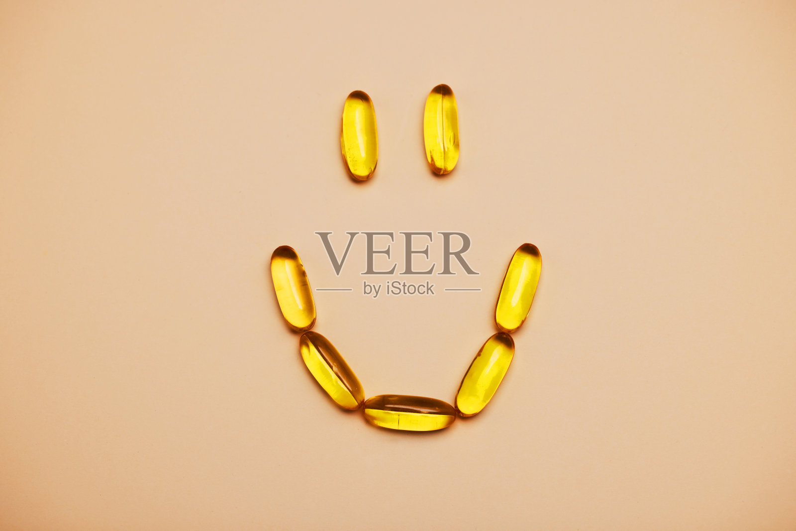 在橘黄色的背景下，药丸形成了一个笑脸照片摄影图片