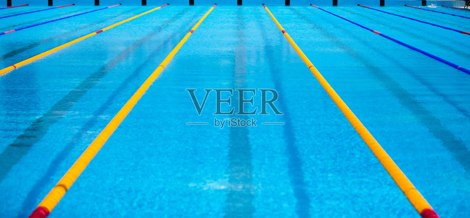 空游泳池，比赛泳道为背景。照片摄影图片