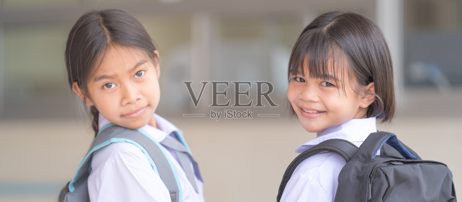 在新冠肺炎疫情隔离和封锁后，身穿校服、背着书包的学生们看着摄像机回到学校。回到学校概念库存照片照片摄影图片