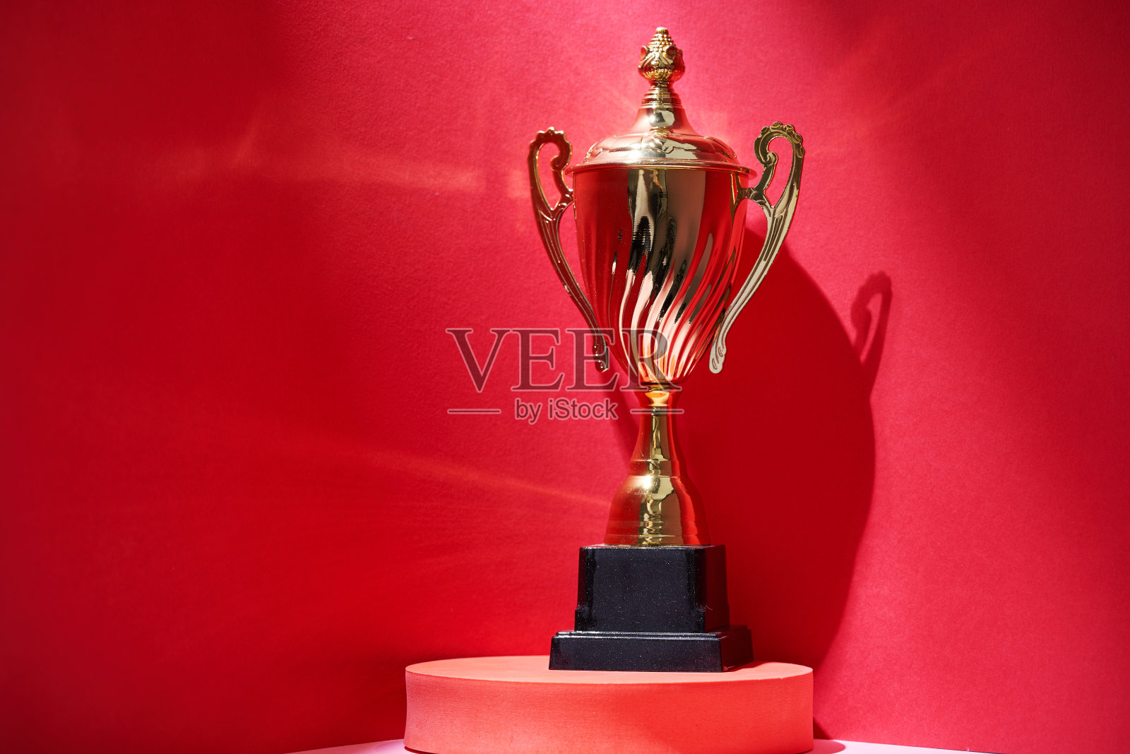 靠近红色背景下的奖杯照片摄影图片