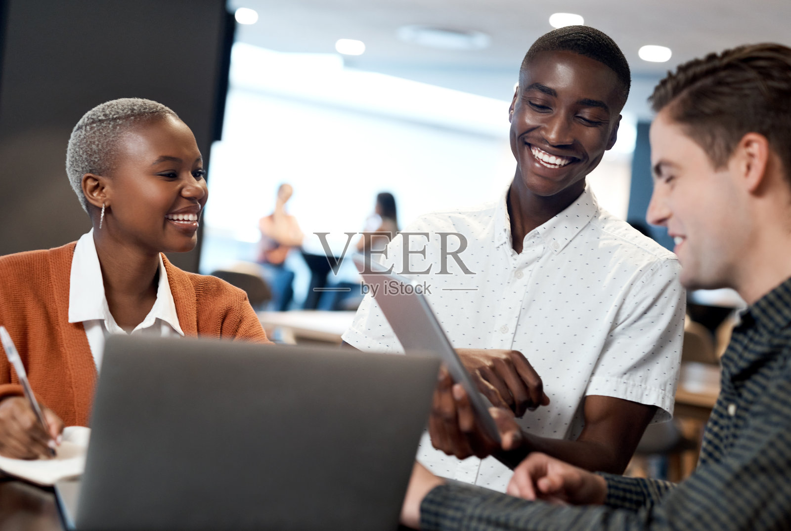 一群年轻的商务人士在现代办公室里开会时使用笔记本电脑照片摄影图片