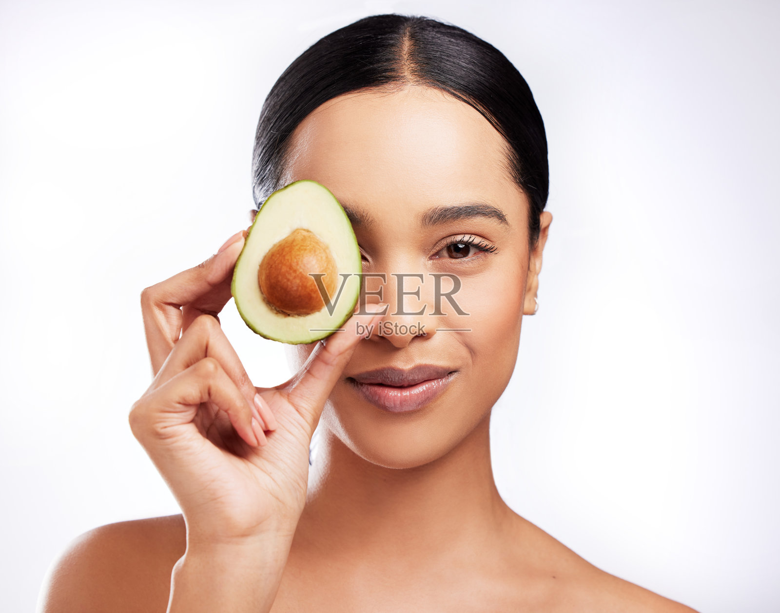 一个美丽的年轻女子在白色背景下摆着牛油果的画室肖像照片摄影图片