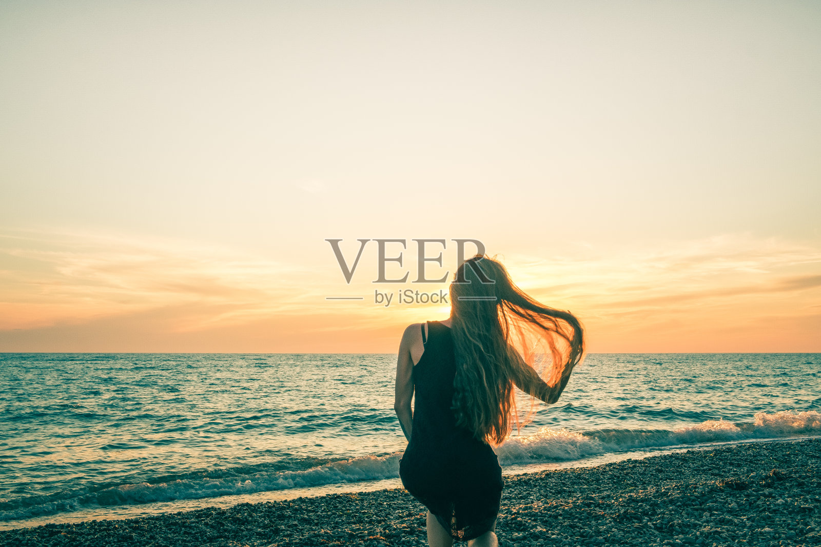 日落背景下一个苗条女孩的剪影照片摄影图片