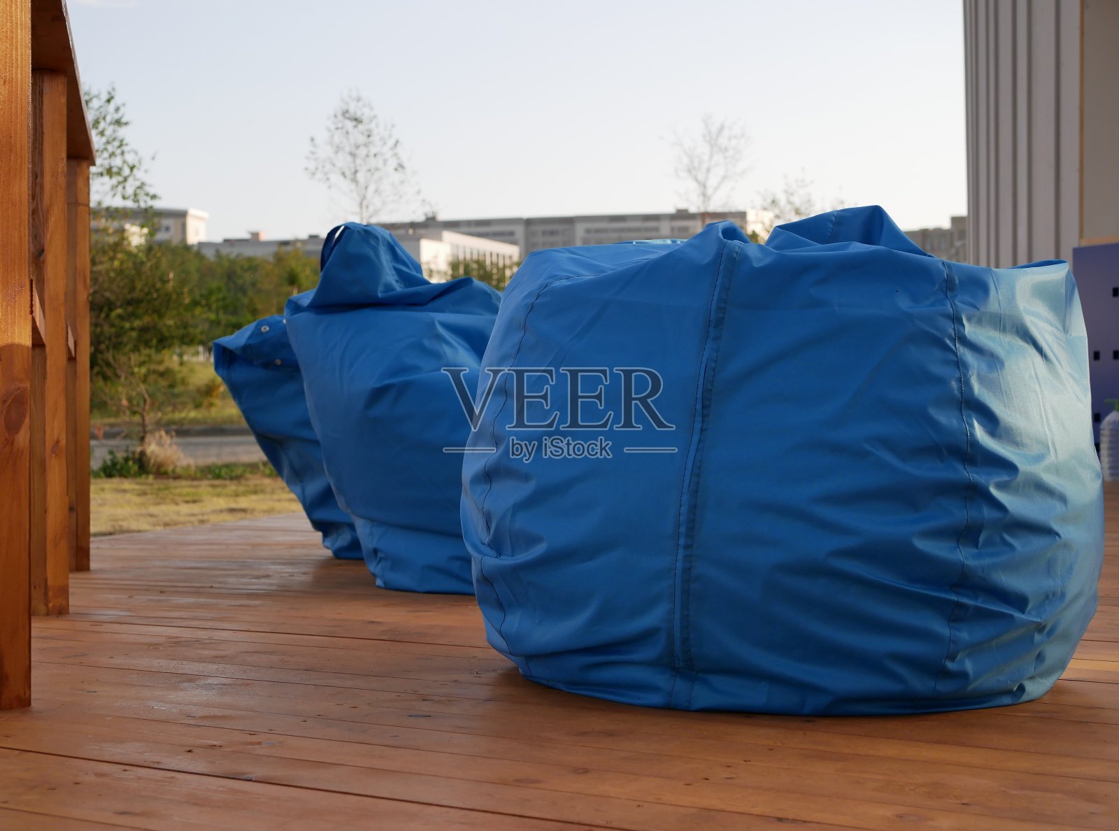 一个阳光明媚的夏日，户外休闲区的一张不同颜色的包椅。户外咖啡馆有家具，但没有客人。照片摄影图片