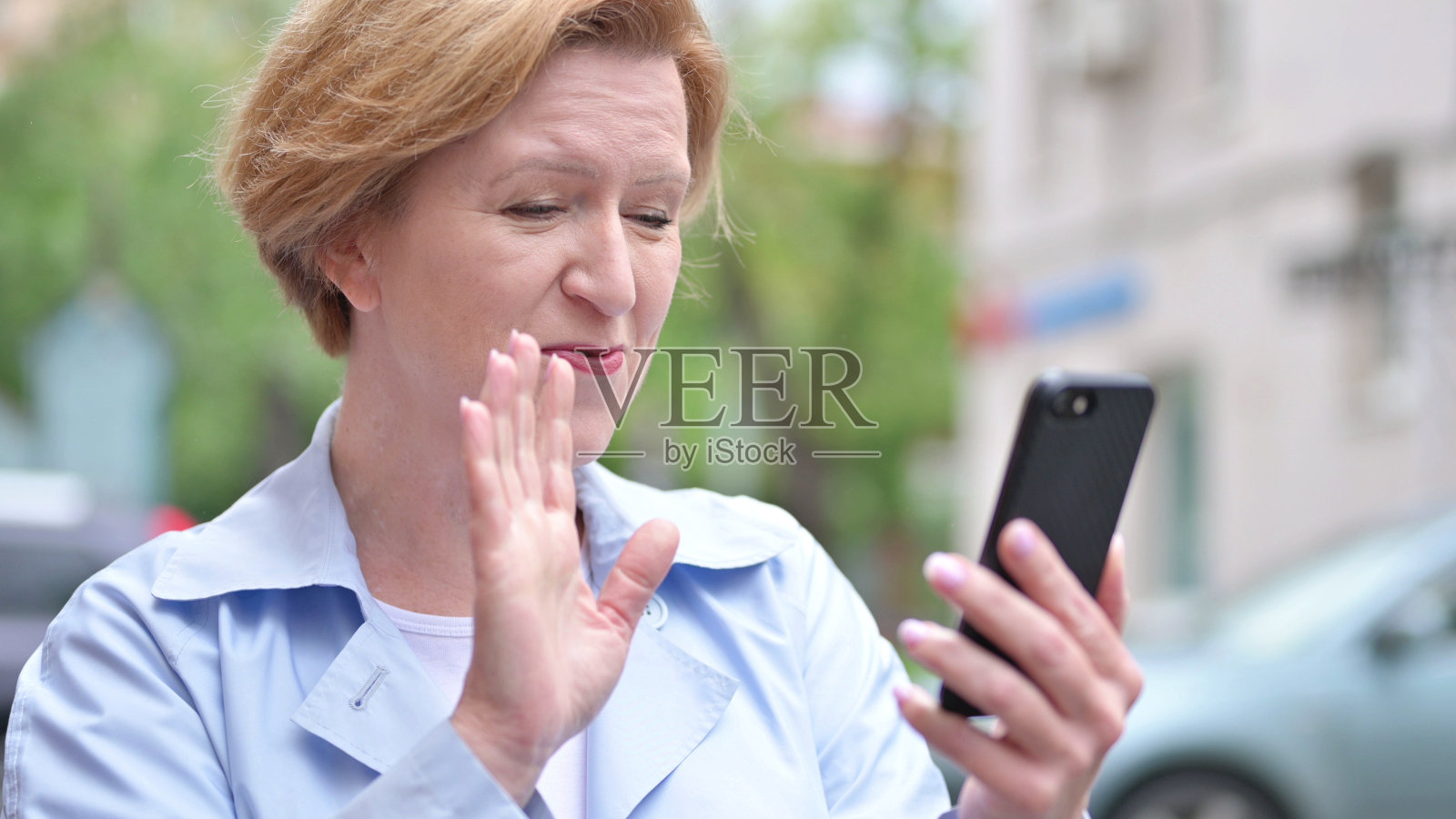 老妇人用智能手机进行户外视频聊天照片摄影图片