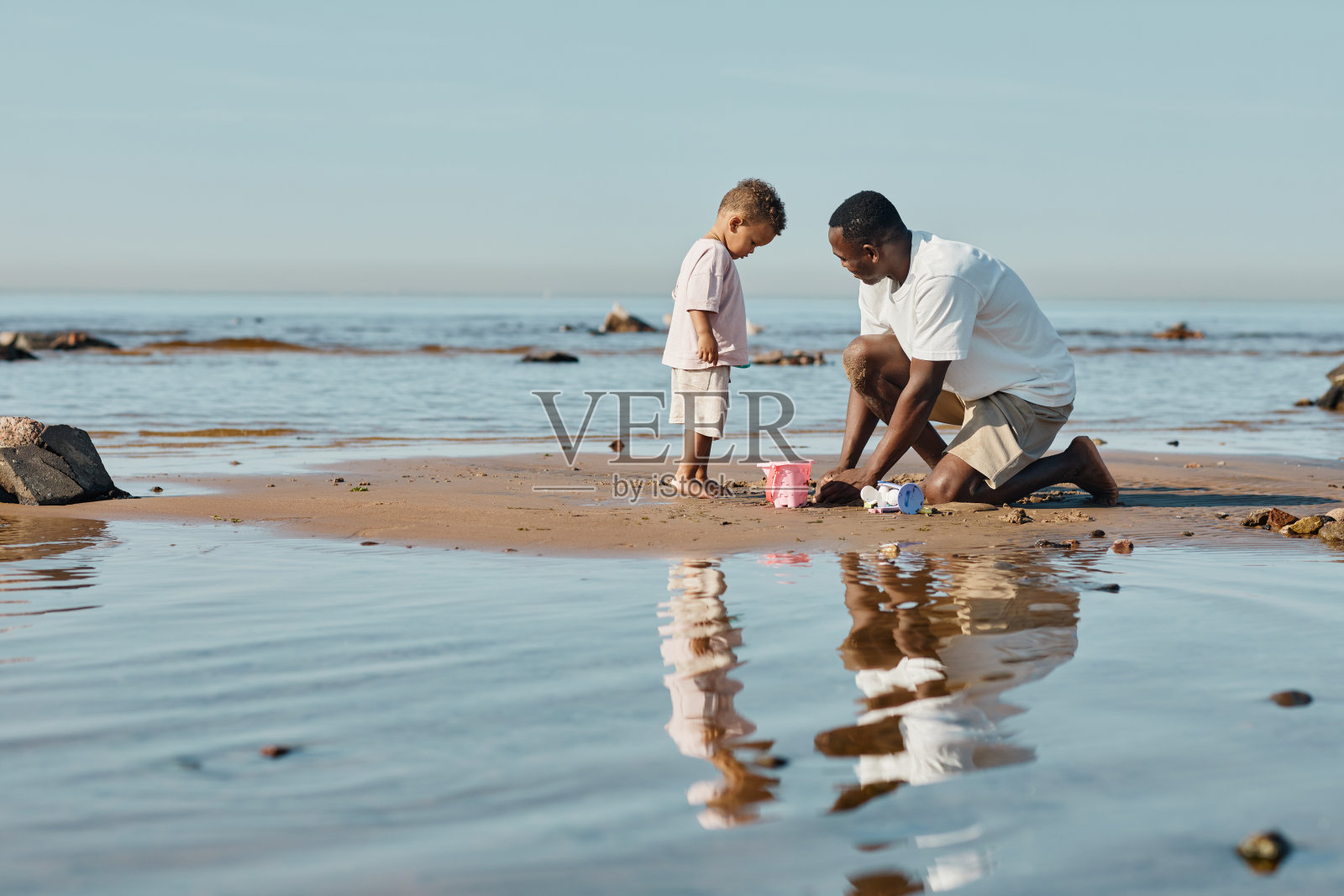 父子在水旁玩耍照片摄影图片