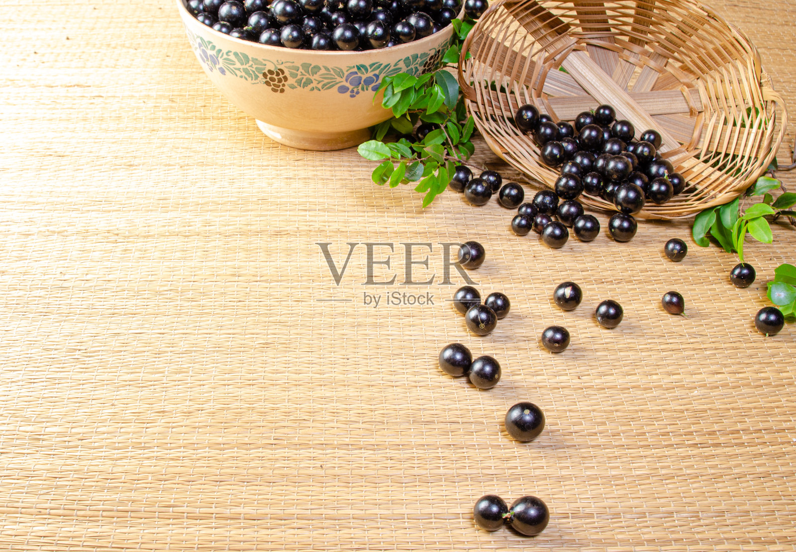 Jabuticaba, Jabuticaba新鲜收获在碗和篮子安排在草席上，选择性聚焦。照片摄影图片