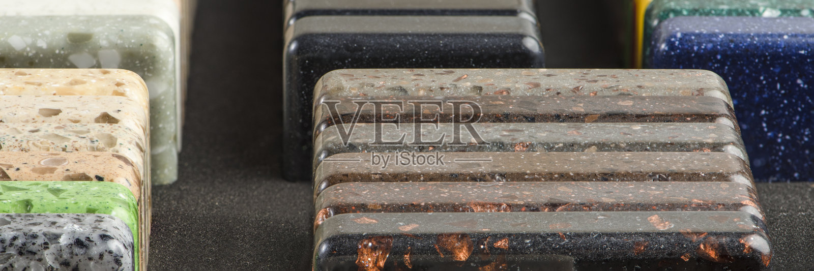 大量选择的石头样品的台面和地板。样品盒里的人造丙烯酸石块。一套不同纹理的色调的台面照片摄影图片