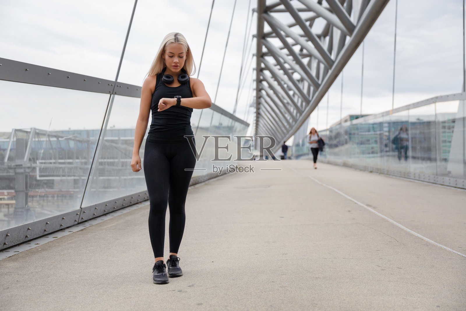 散步的女人在锻炼后使用智能手表查看心率照片摄影图片