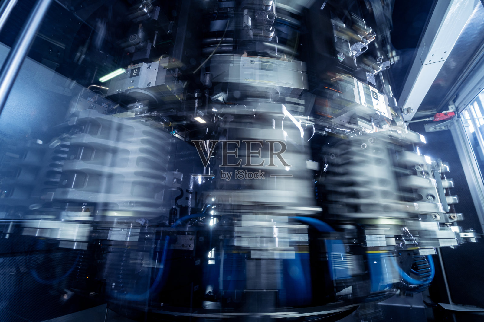 现代化饮料厂的PET塑料瓶自动灌装机。照片摄影图片