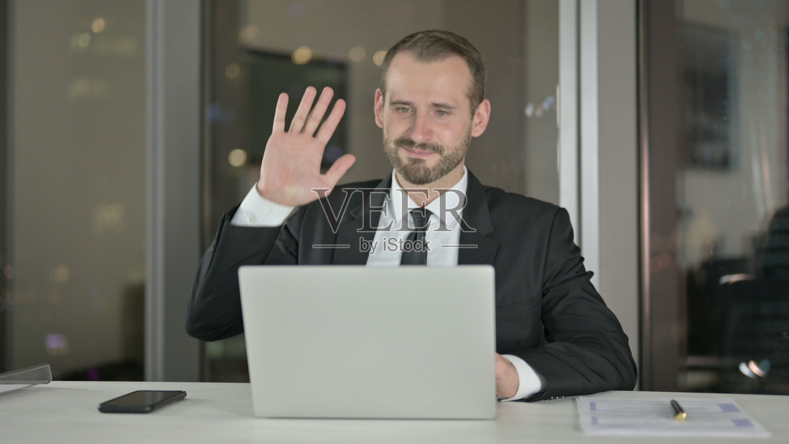 雄心勃勃的商人在晚上用笔记本电脑进行视频聊天照片摄影图片