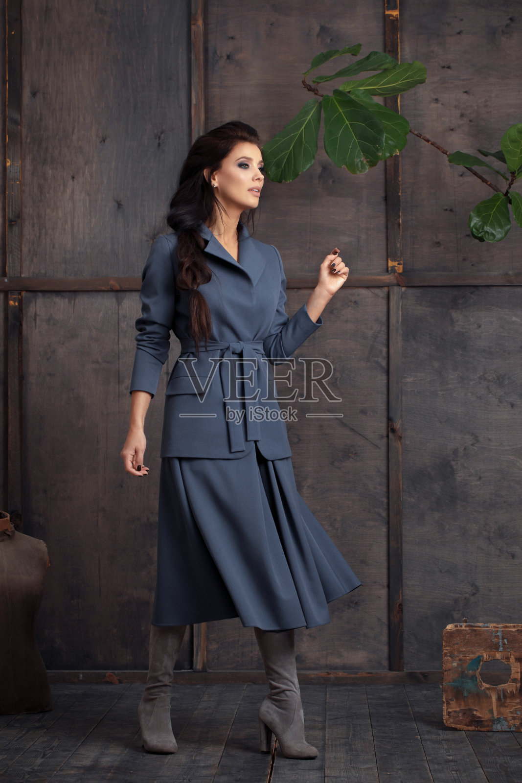 工作室肖像自信年轻的女时装模特长发在时尚的商务服装在蓝色色调。收集舒适的商务服装。照片摄影图片