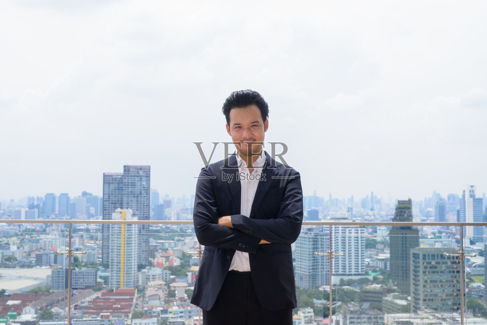 城市屋顶上的亚洲商人穿着西装的肖像照片摄影图片